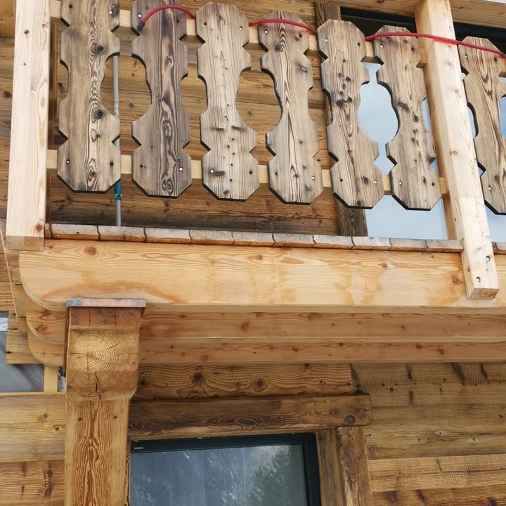Balcon en mélèze avec balustres découpés de récupération