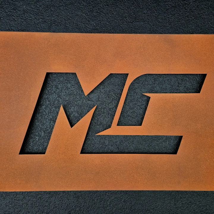 Logo découpé dans une plaque de fer rouillé, posé sur un mur